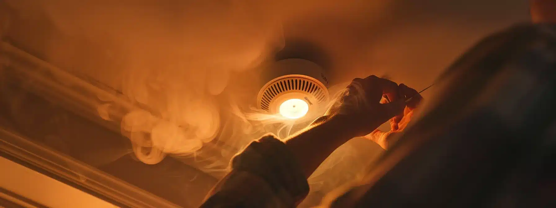 a person securing a loose outlet and checking smoke alarm.