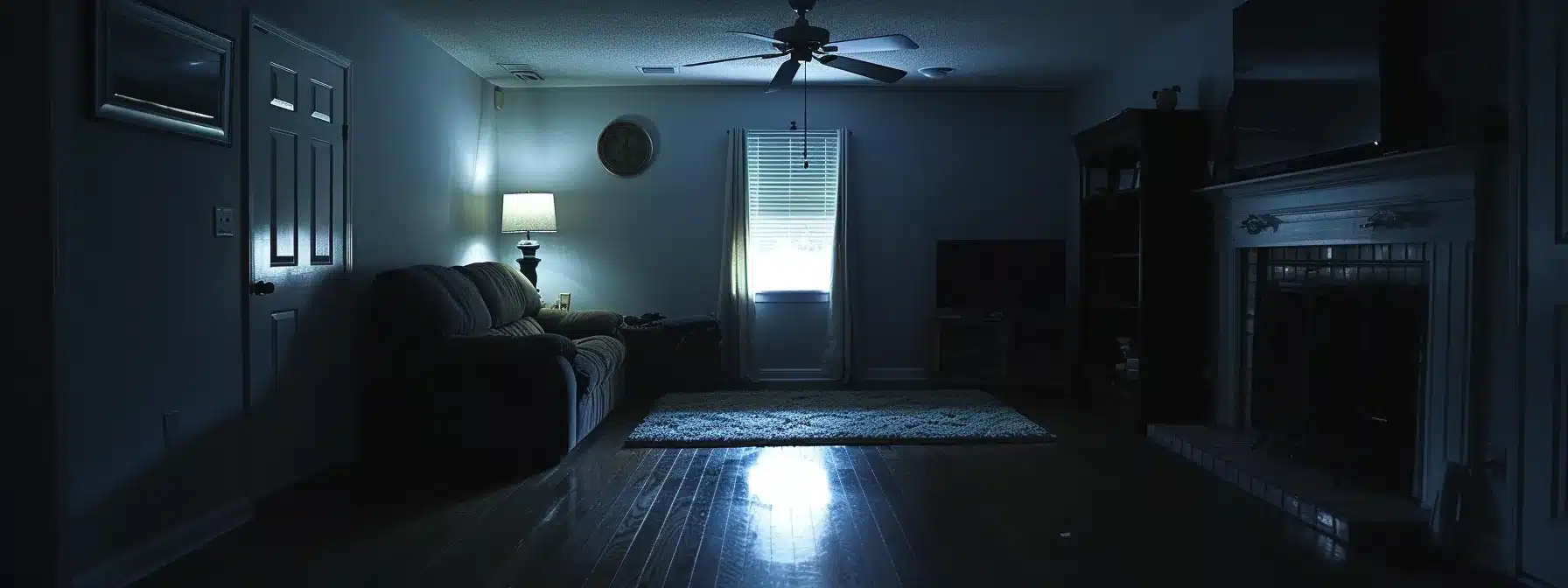 a dark room with a ceiling fan motionless, illuminated only by a small flashlight.